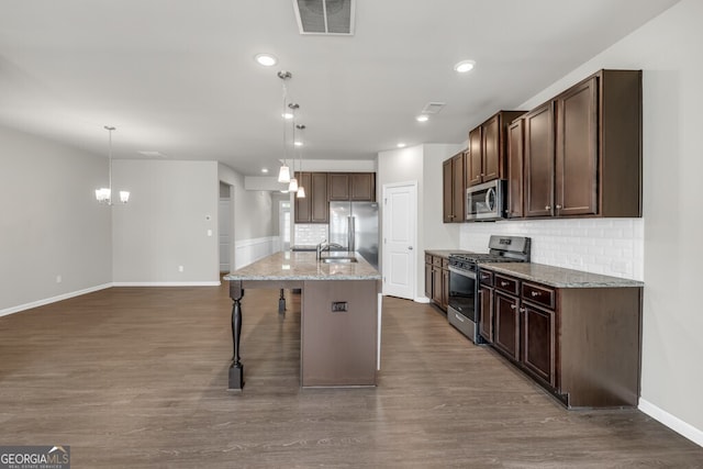 kitchen with appliances with stainless steel finishes, baseboards, a sink, a chandelier, and dark wood finished floors