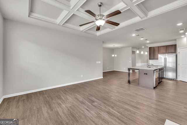 kitchen with stainless steel appliances, coffered ceiling, a ceiling fan, baseboards, and a breakfast bar