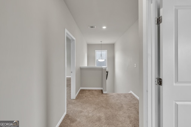 hall with an upstairs landing, carpet floors, baseboards, and recessed lighting