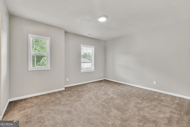 carpeted empty room featuring baseboards