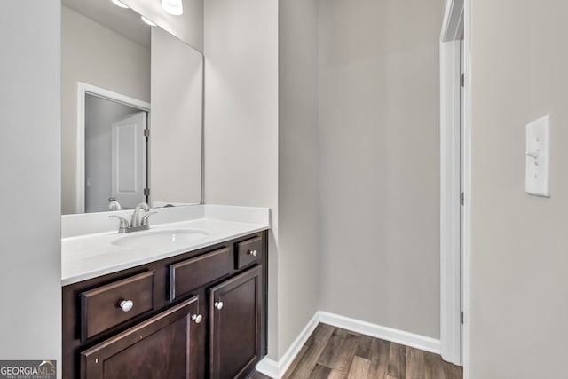 bathroom with wood finished floors, vanity, and baseboards