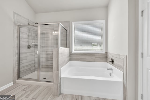 bathroom with a stall shower and a garden tub