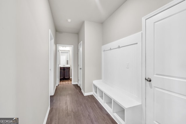 mudroom featuring baseboards and dark wood-style floors