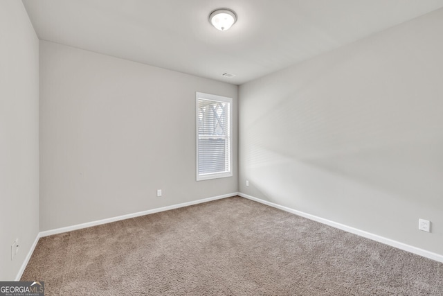 carpeted spare room with baseboards