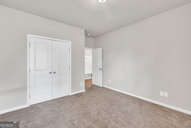 unfurnished bedroom with carpet, baseboards, and a closet