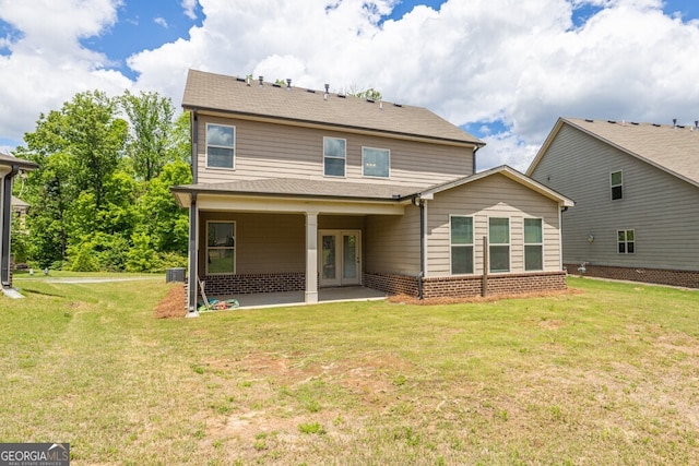 back of house featuring french doors, a patio, a yard, brick siding, and central AC unit