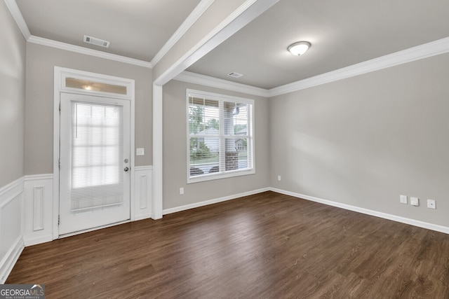 foyer with wood finished floors, ornamental molding, and baseboards