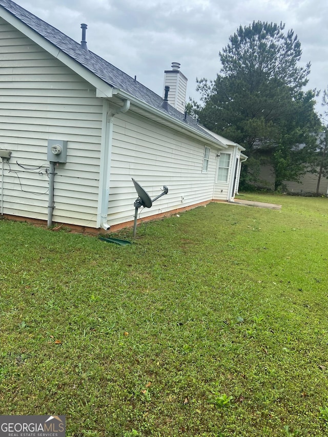 248 Fern Ct, Hampton, GA 30228 - back of house with a lawn, a chimney, and a shingled roof
