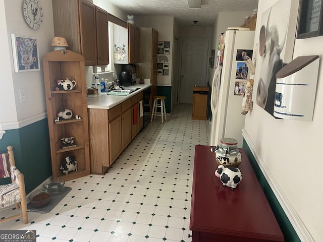 248 Fern Ct, Hampton, GA 30228 - kitchen with a sink, freestanding refrigerator, light floors, light countertops, and baseboards
