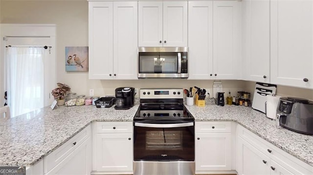 40 Luther Knight Rd, Cartersville, GA 30121 - kitchen featuring a peninsula, white cabinetry, light stone counters, and appliances with stainless steel finishes