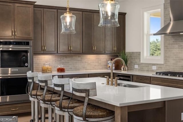 5247 Flannery Chase SW, Powder Springs, GA 30127 - kitchen with wall chimney range hood, appliances with stainless steel finishes, a sink, light countertops, and decorative light fixtures
