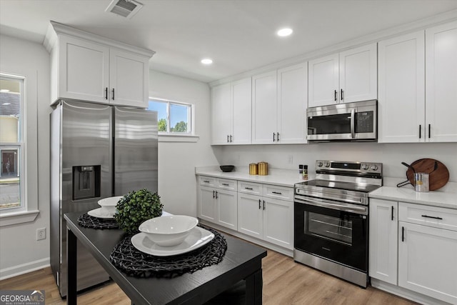 3634 Oakleaf Pass, Fairburn, GA 30213 - kitchen featuring light countertops, appliances with stainless steel finishes, visible vents, and white cabinetry