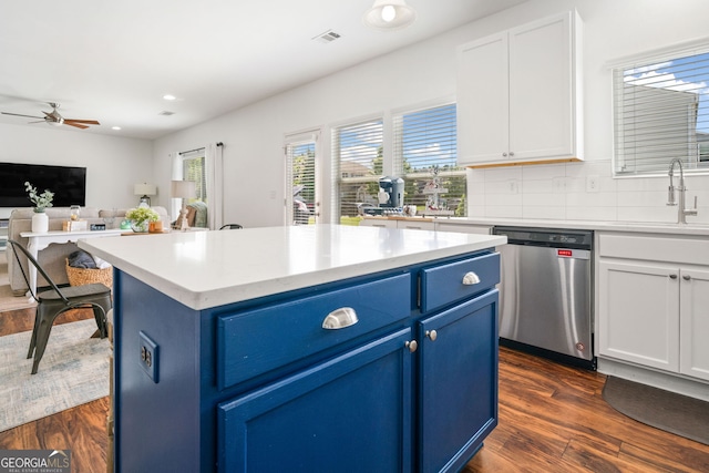 kitchen with dishwasher, blue cabinets, a sink, ceiling fan, and dark wood-style floors