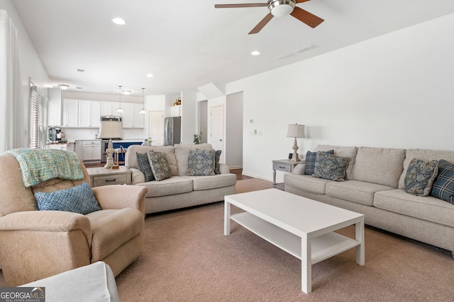 living room featuring ceiling fan, recessed lighting, light colored carpet, and baseboards