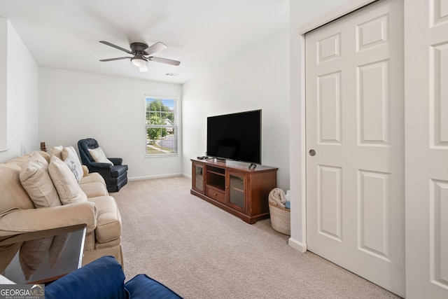 living room with light carpet, a ceiling fan, and baseboards