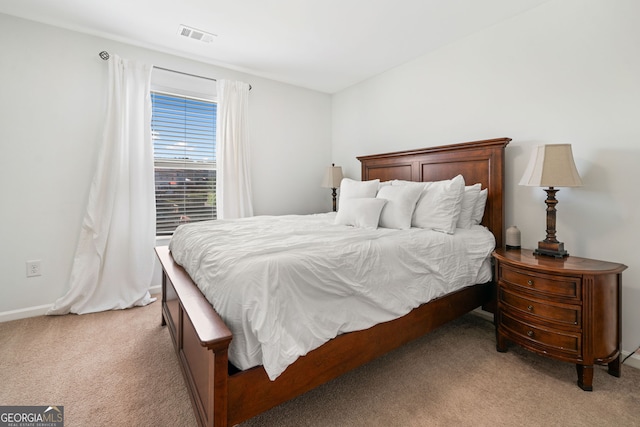 bedroom with light colored carpet and baseboards