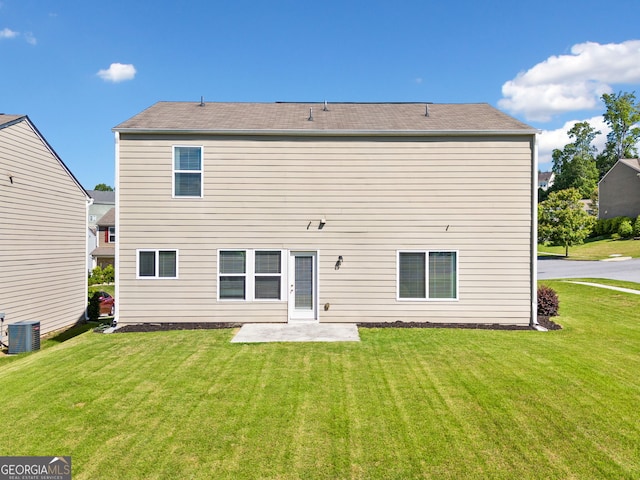 rear view of property with central AC, a lawn, and a patio area