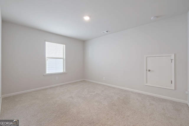 carpeted empty room with visible vents and baseboards