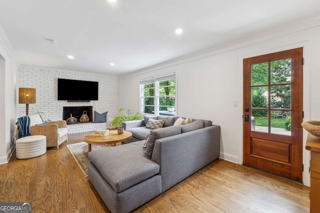 living area with light wood-style floors, crown molding, recessed lighting, and baseboards
