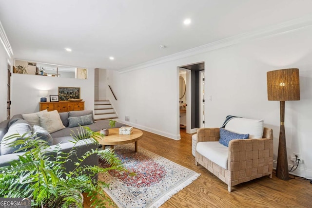 living area featuring ornamental molding, stairway, light wood finished floors, baseboards, and recessed lighting