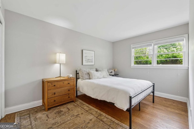 bedroom with baseboards and wood finished floors