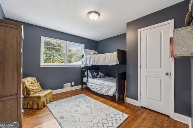 bedroom with wood finished floors and baseboards
