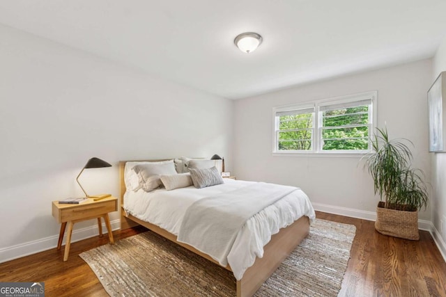 bedroom featuring wood finished floors and baseboards