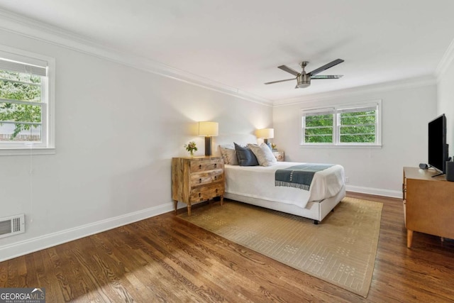 bedroom featuring crown molding, baseboards, wood finished floors, and ceiling fan
