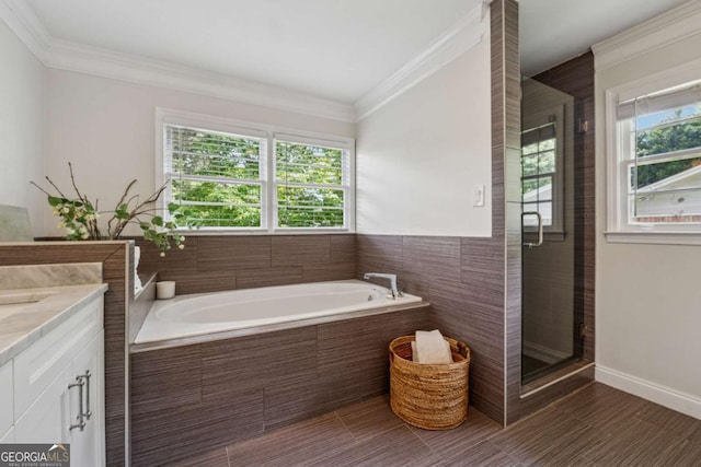 bathroom featuring ornamental molding, a garden tub, vanity, and a stall shower