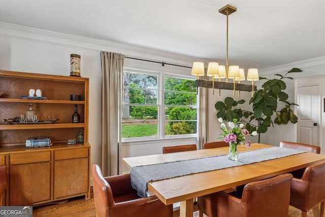 dining room featuring crown molding, a chandelier, and light wood finished floors