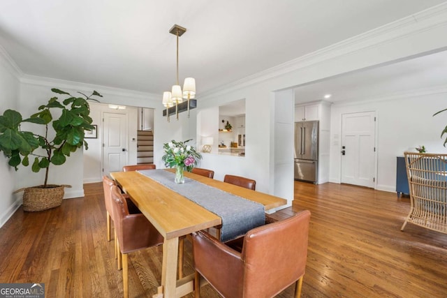 dining area featuring stairs, a chandelier, crown molding, wood finished floors, and baseboards