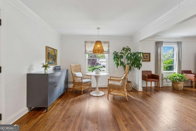 living area with hardwood / wood-style floors, crown molding, and baseboards