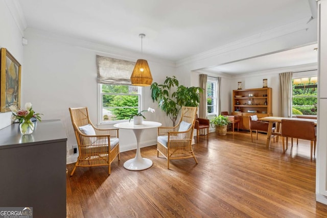 sitting room featuring ornamental molding and wood finished floors