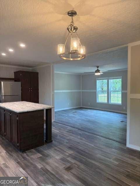 236 Dewaters Rd, Commerce, GA 30529 - kitchen featuring freestanding refrigerator, crown molding, dark brown cabinets, dark wood-type flooring, and a ceiling fan
