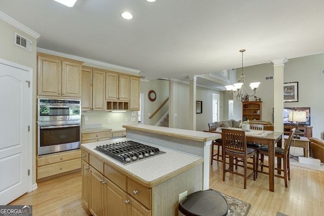kitchen featuring light wood finished floors, stainless steel appliances, visible vents, and open floor plan