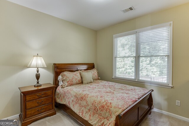 bedroom featuring visible vents, baseboards, and light carpet