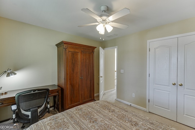 office space featuring visible vents, baseboards, ceiling fan, and light carpet
