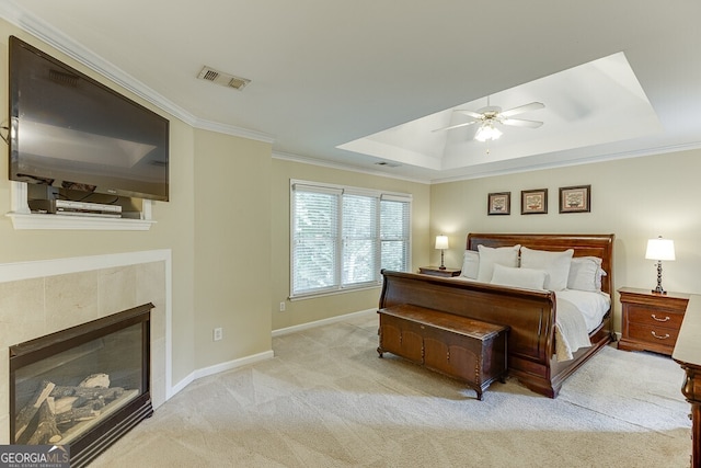 bedroom featuring carpet, a tray ceiling, visible vents, baseboards, and ornamental molding