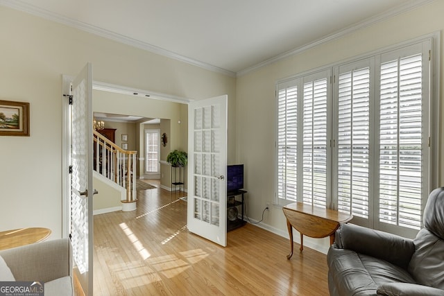 living area featuring stairway, light wood-type flooring, and a healthy amount of sunlight