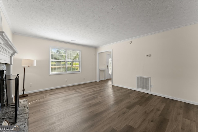 unfurnished living room with wood finished floors, a textured ceiling, a fireplace with raised hearth, visible vents, and crown molding