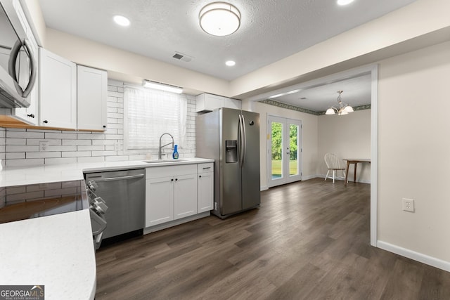 kitchen featuring a sink, stainless steel appliances, visible vents, and white cabinets