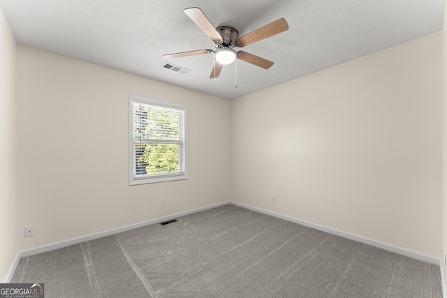 carpeted spare room featuring visible vents, baseboards, and a ceiling fan