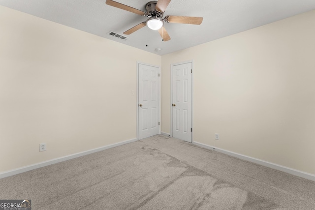 unfurnished room with a ceiling fan, baseboards, carpet flooring, and visible vents
