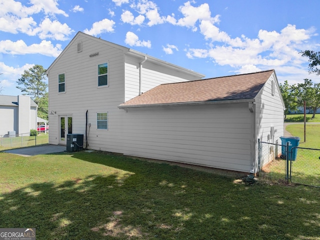 back of house with a gate, fence, cooling unit, and a lawn