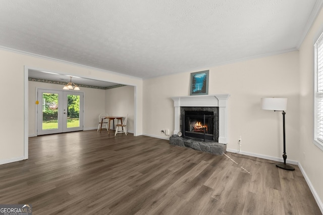 unfurnished living room featuring a premium fireplace, ornamental molding, a textured ceiling, and wood finished floors