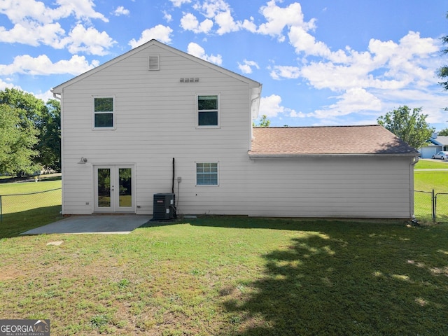 rear view of house with french doors, a patio area, fence, and a lawn