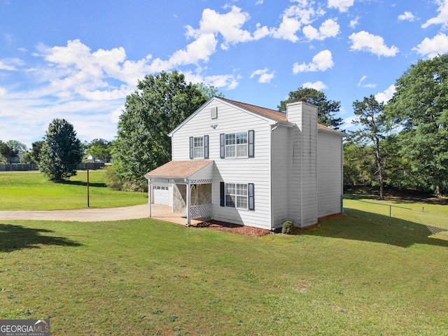view of front facade with a chimney, driveway, fence, a garage, and a front yard