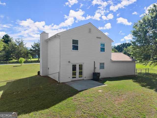 back of property with a lawn, a chimney, french doors, fence, and a patio
