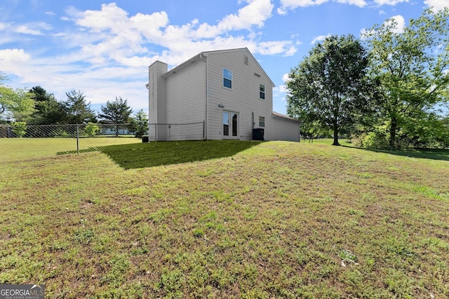 view of side of home with a yard, a chimney, and fence