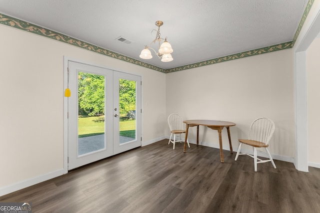 dining room with french doors, wood finished floors, visible vents, a notable chandelier, and baseboards